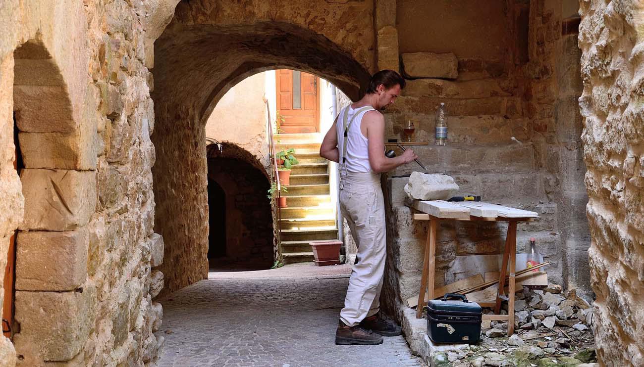 un tailleur de pierre sous un passage couvert